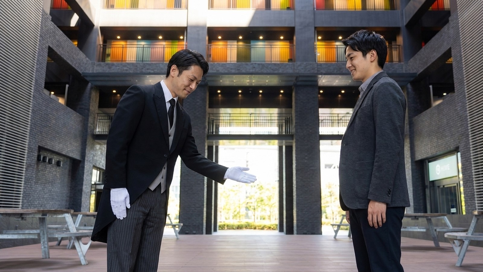入学案内の資料を手に持ち丁寧に説明する執事の様子