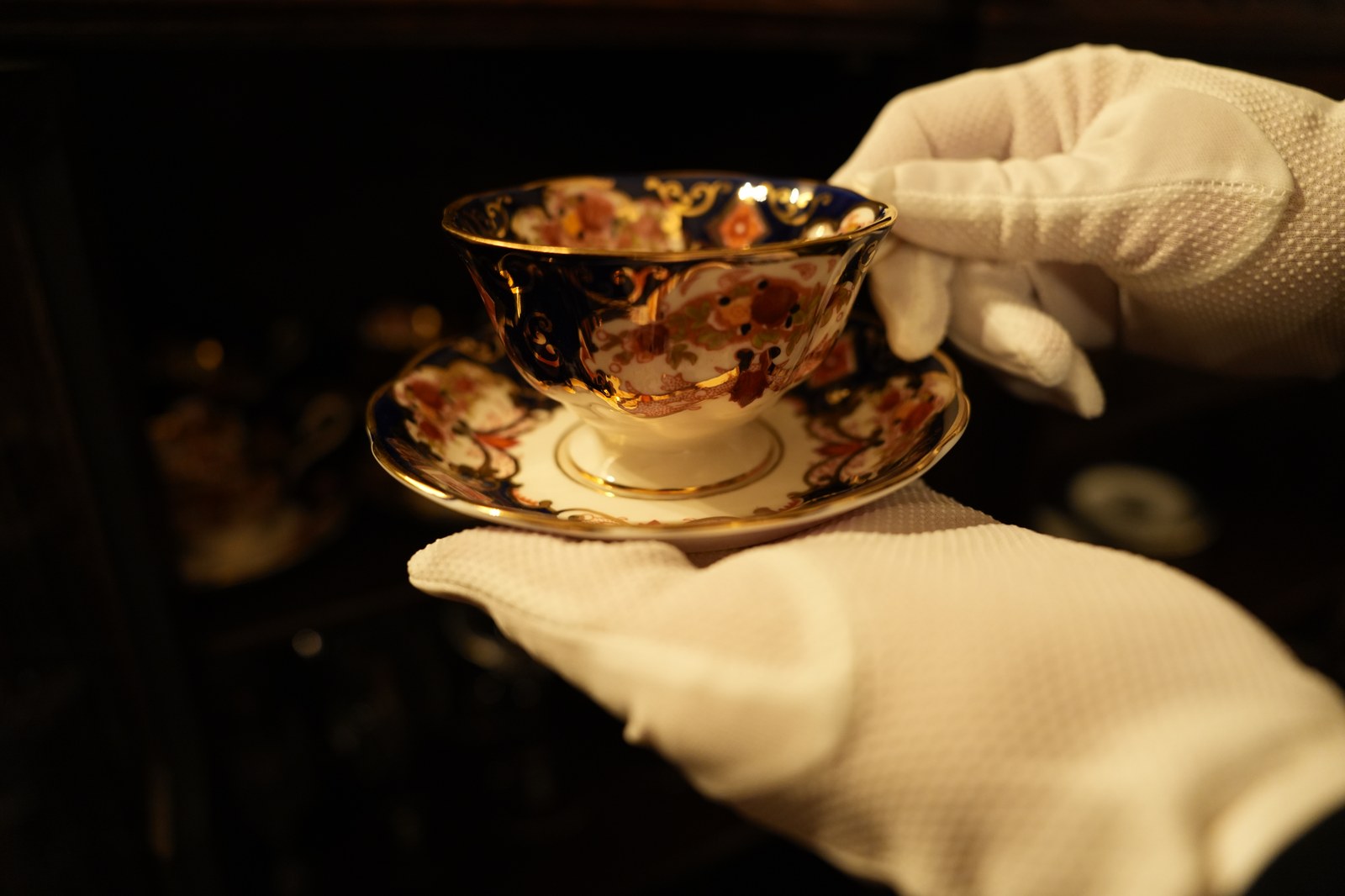 A gloved hand presenting a cup (photograph from the Butler Bell site)