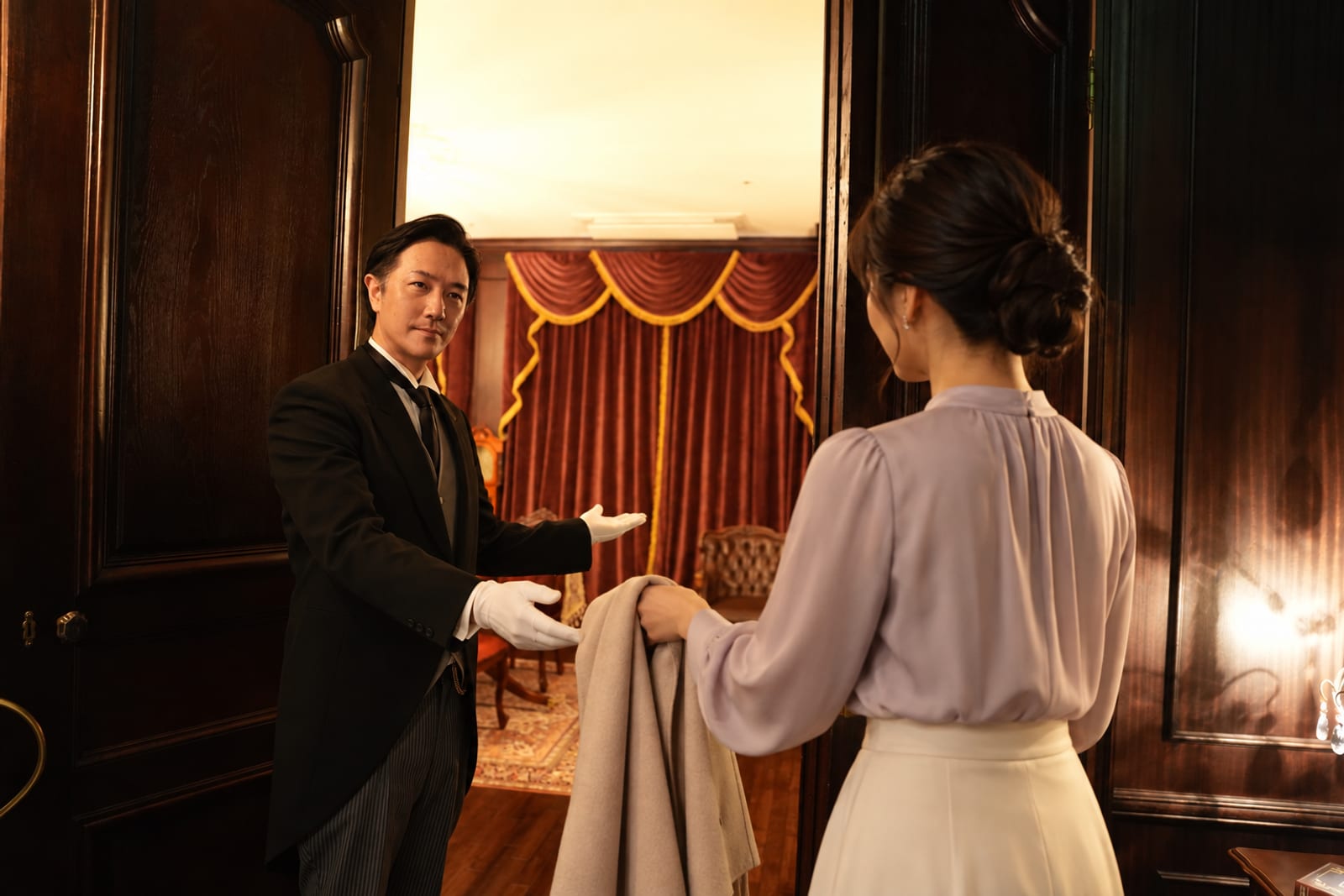 A butler receiving a guest at the door (Queen's Butler photograph)